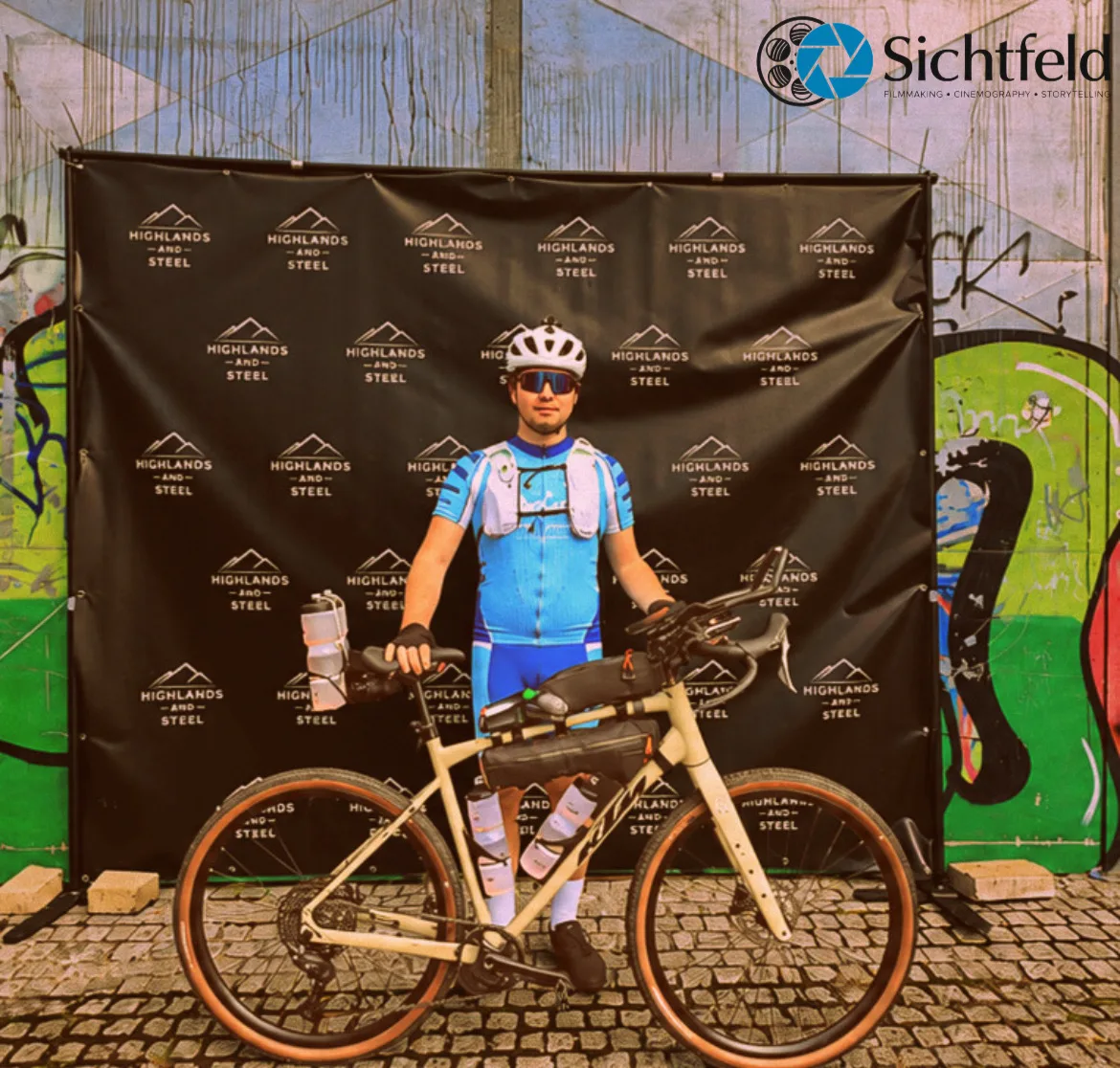 Silas mit seinem Rad vor der Highlands-and-Steel-Fotowand